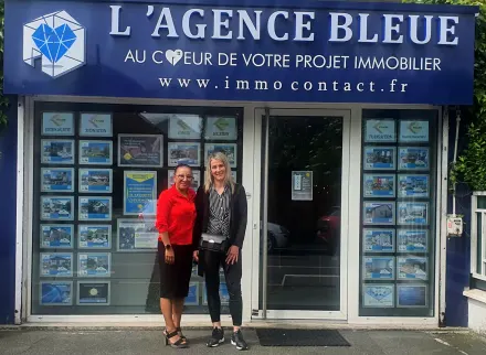 Nora devant une agence immobilière partenaire